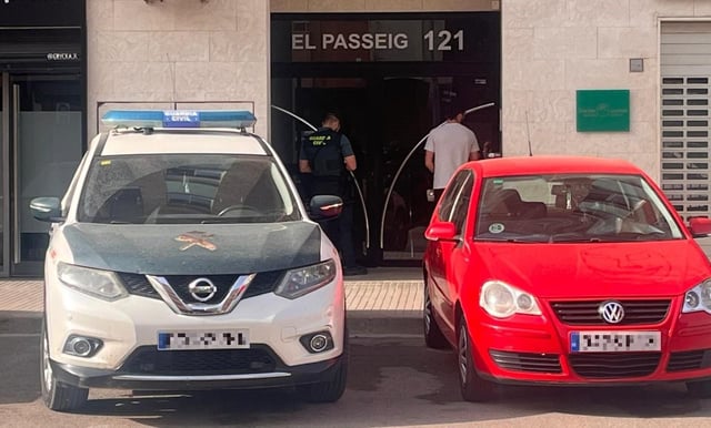 Un coche patrulla de la Guardia Civil, esta mañana, frente a la puerta de la vivienda en la que fue hallada la víctima, en Riba-roja de Túria.