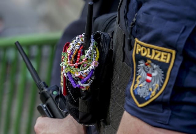 FILE - A police officer is decorated with Taylor Swift bracelets while guarding the city center in Vienna on Aug. 8, 2024. (AP Photo/Heinz-Peter Bader, File)