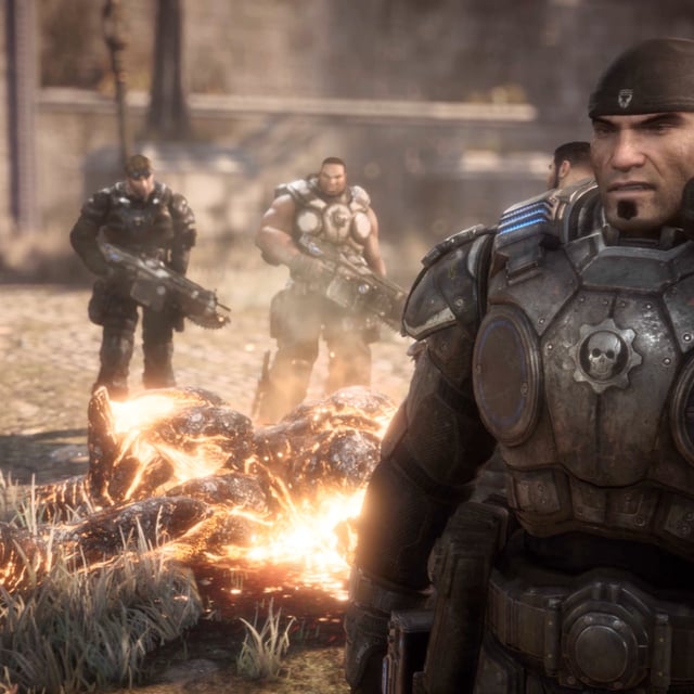 Marcus standing in front of a burning corpse in Gears of War: Reloaded