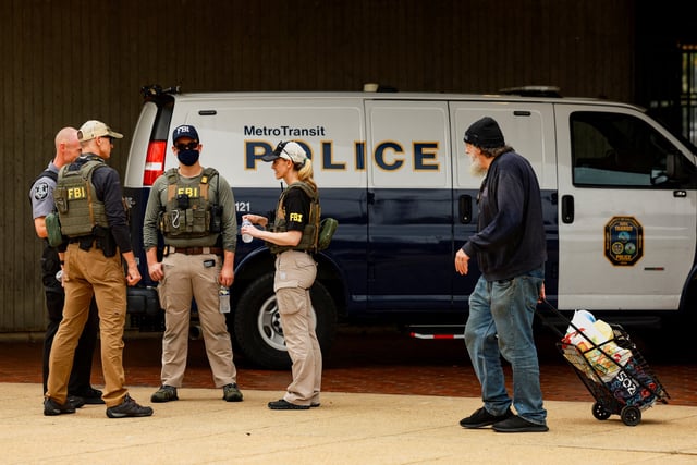 FBI agents gather in front of a Metro Transit Police van near the Anacostia bus station, after U.S. President Donald Trump deployed U.S. National Guard troops to Washington and ordered an increase in the presence of federal law enforcement to assist in crime prevention, in Washington, D.C., U.S., August 20, 2025. REUTERS/Jose Luis Gonzalez/File Photo