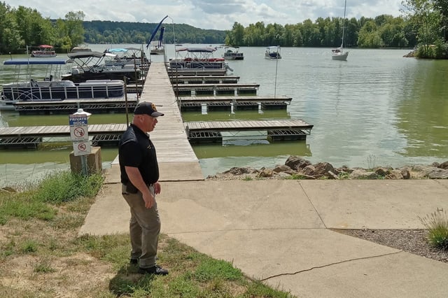 A Tuscarawas County Sheriff  stands next to skid marks that were left on a sidewalk when a woman drove a golf cart into Atwood Lake on Aug. 23. 