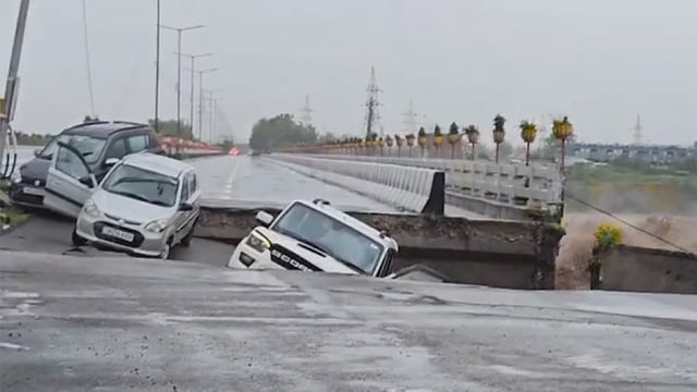 Vehicles remain stranded after the road near the fourth Tawi bridge was washed away due to swelling waterbodies following incessant heavy rainfall, in Jammu, (IANS)