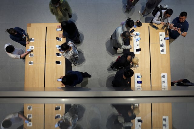 Staff members attend to customers as the new iPhone 16 series smartphones go on sale at an Apple store in Beijing, China September 20, 2024.