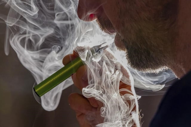 A man vapes on a disposable electronic cigarette in Brussels on Dec. 12, 2024, ahead of Belgium's ban on the sale of disposable vapes as of Jan. 1, 2025. 