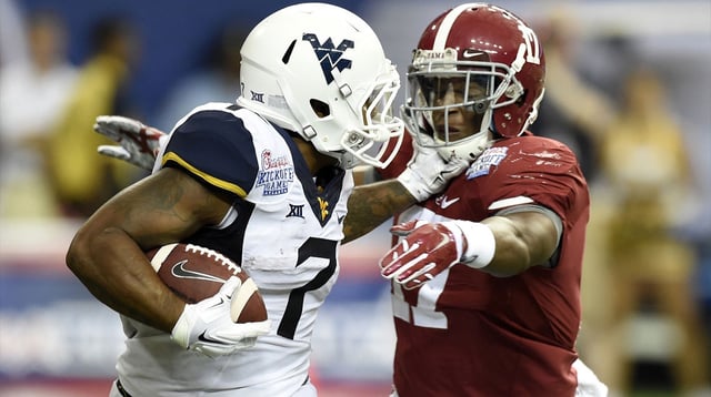 Aug 30, 2014; Atlanta, GA, USA; West Virginia Mountaineers running back Rushel Shell (7) stiff arms Alabama Crimson Tide running back Kenyan Drake (17) on a kick off during the third quarter of the 2014 Chick-fil-a kickoff game at Georgia Dome. Mandatory Credit: John David Mercer-Imagn Images