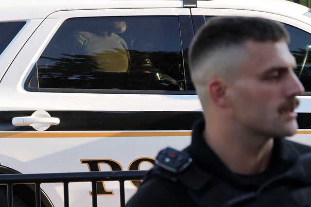A US Secret Service Uniformed Division officer detains a man that burned a US flag at the edge of Lafayette Park, across from the White House, on Monday.