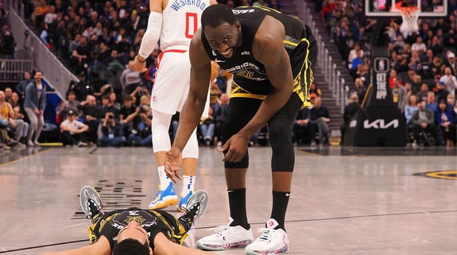 Mar 2, 2023; San Francisco, California, USA; Golden State Warriors center Draymond Green (23) smiles as he helps up guard Jordan Poole (3) after Poole drew an offensive charge from Los Angeles Clippers point guard Russell Westbrook (0) during the third quarter at Chase Center. Mandatory Credit: Kelley L Cox-Imagn Images