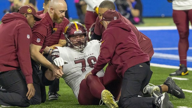 Jan 18, 2025; Detroit, Michigan, USA; Washington Commanders guard Sam Cosmi (76) received medical on the field after an injury during play against Detroit Lions during the second quarter at Ford Field. Mandatory Credit: David Reginek-Imagn Images