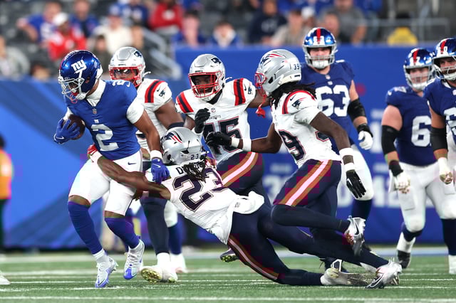 EAST RUTHERFORD, NEW JERSEY - AUGUST 21: Juice Wells Jr. #2 of the New York Giants runs the ball while defended by Kyle Dugger #23 of the New England Patriots during a NFL Preseason 2025 game between New England Patriots and New York Giants at MetLife Stadium on August 21, 2025 in East Rutherford, New Jersey. The Giants won 42-10.