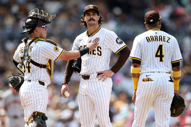 SAN DIEGO, CALIFORNIA - AUGUST 21: Freddy Fermin #54 and Luis Arraez #4 console Dylan Cease #84 of the San Diego Padres as he is taken out of the game during the sixth inning of a game against the San Francisco Giants at Petco Park on August 21, 2025 in San Diego, California.