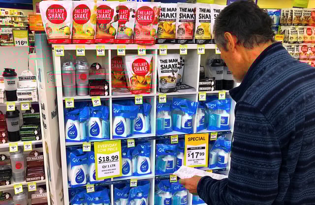 A customer looks at products marked with discounted prices on display at a chemist in a shopping mall in central Sydney, Australia, July 25, 2018.    REUTERS/David Gray/ File Photo