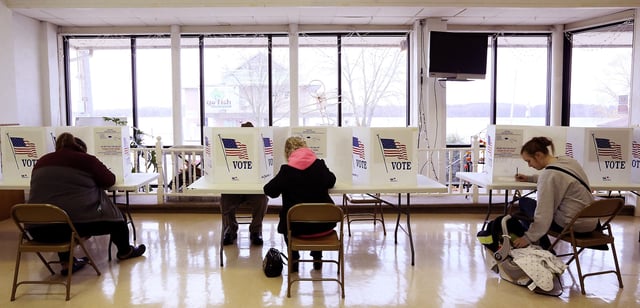 Molly Forbes, right reaches down to check her three-month-old son Elijah while voting at the Princeton Community Center in Princeton, Iowa Tuesday, November 6, 2018.