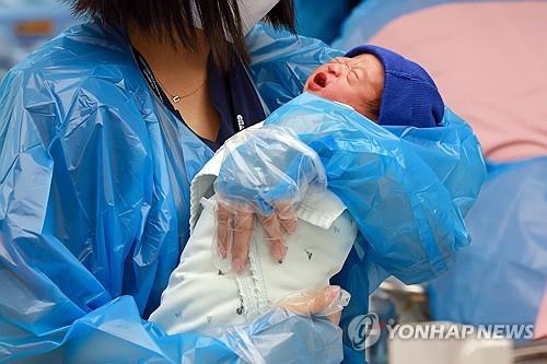 This file photo taken July 24, 2025, shows a nurse holding a baby at a hospital in the city of Goyang, Gyeonggi Province. (Yonhap)