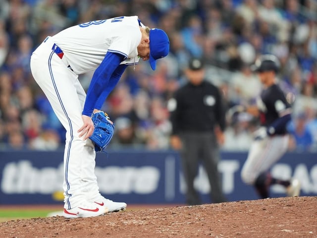 Toronto Blue Jays pitcher Jeff Hoffman (left) reacts on the mound after giving up a three-run home run to Minnesota Twins' Matt Wallner (back right) during ninth inning MLB baseball action in Toronto on Tuesday, August 26, 2025.
