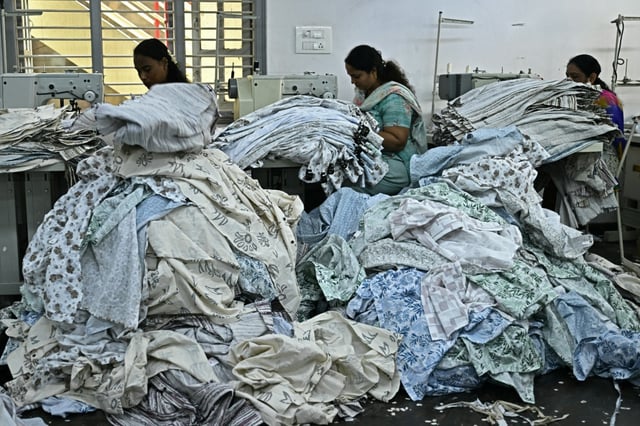 Des ouvrières confectionnent des vêtements sur des machines à coudre dans une usine de fabrication à Bengaluru, en Inde, le 25 août 2025