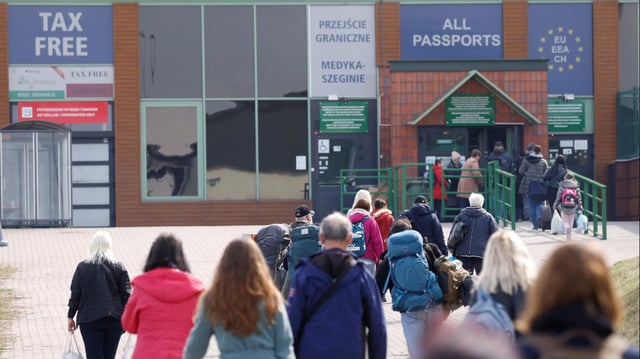 Ukrainische Flüchtlinge gehen in Richtung Grenzübergang von Polen in die Ukraine.