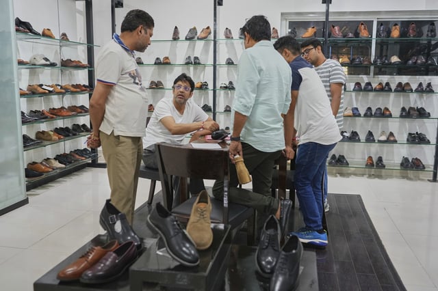Sambhav Dawar, a senior manager, talks to his production line supervisors at the Dawar leather footwear manufacturing industry in Agra, India, Monday, Aug. 25, 2025. (AP Photo/Manish Swarup)