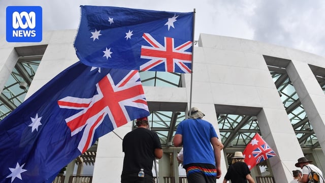 People holding Australian flags outside Parliament House in Canberra.