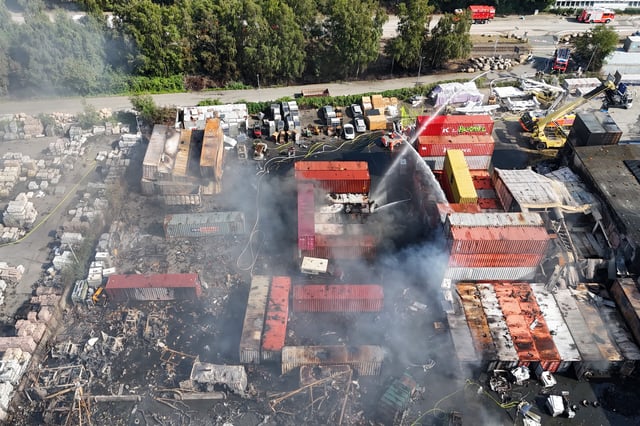 Einsatzkräfte der Feuerwehr löschen den Großbrand auf der Veddel in Hamburg.
