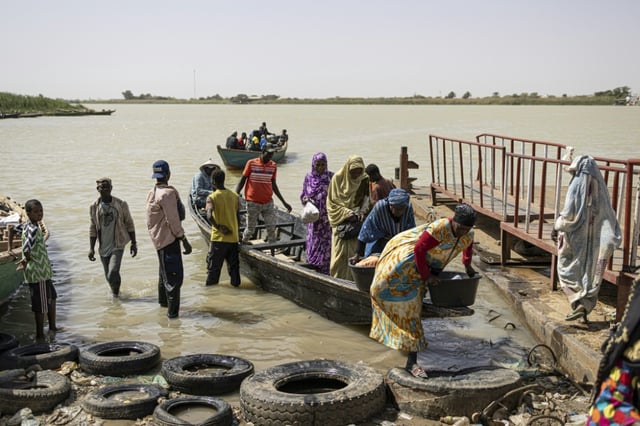 Des passagers provenant de la rive mauritanienne du fleuve Sénégal débarquent d'une pirogue à Rosso, au Sénégal, le 20 mars 2025