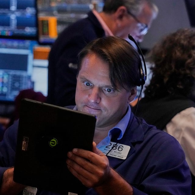 Trader Michael Milano left, works on the floor of the New York Stock Exchange, Monday, Aug. 18, 2025. (AP Photo/Richard Drew)