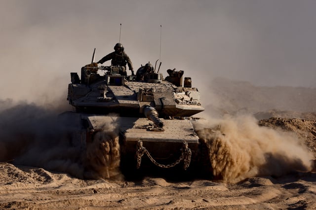An Israeli tank manouvres at the Israel-Gaza border, as seen from Israel, August 26, 2025. REUTERS/Amir Cohen/File Photo