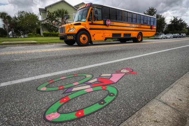 A bicycle lane at the intersection of Laureate Boulevard and Benavente Avenue, outside  Laureate Park Elementary School in Lake Nona, on Tuesday, Aug. 26, 2025. The art on the bicycle lane will be painted over by FDOT. (Ricardo Ramirez Buxeda/Orlando Sentinel)