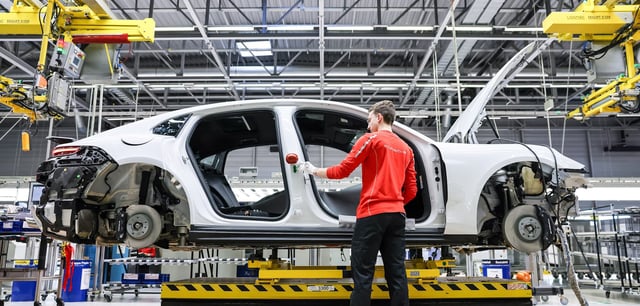 Ein Mitarbeiter montiert einen Porsche Panamera im Werk Leipzig