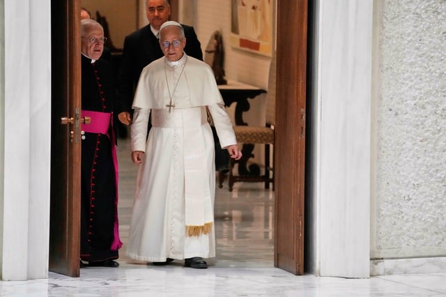 Pope Leo XIV talks to Monsignor Leonardo Sapienza as he arrives in the Paul IV hall on the occasion of the weekly general audience at the Vatican, Wednesday, Aug. 27, 2025. (AP Photo/Gregorio Borgia)