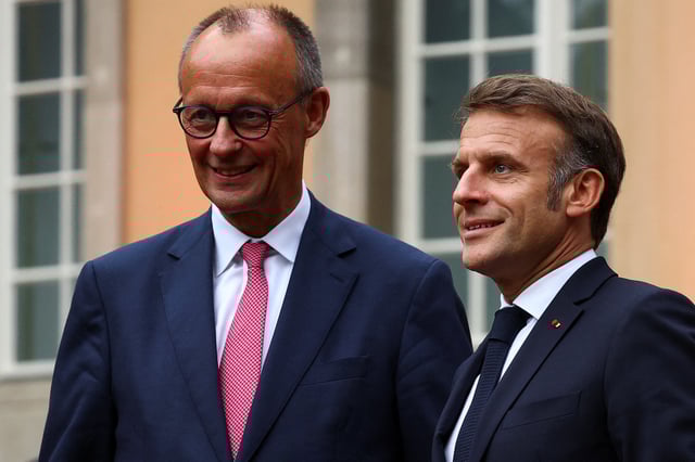 German Chancellor Friedrich Merz stands next to French President Emmanuel Macron as he welcomes him for bilateral talks at Villa Borsig in Berlin, Germany July 23, 2025. REUTERS/Lisi Niesner/File Photo