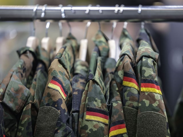 Feldjacken hängen am Stand der Bundeswehr bei der Computerspiele-Messe Gamescom.