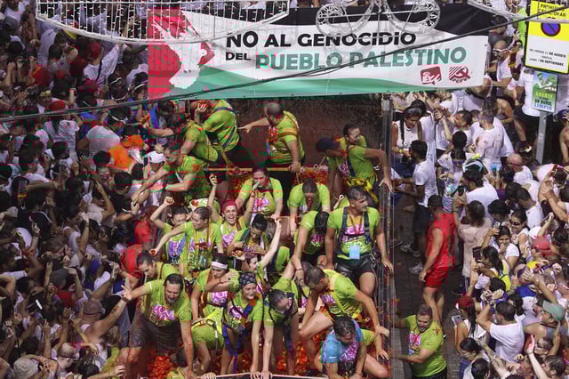 Revelers throw tomatoes at each other during the annual "Tomatina" tomato fight fiesta, in the village of Bunol near Valencia, Spain, Wednesday, Aug. 27, 2025. (AP Photo/Alberto Saiz)