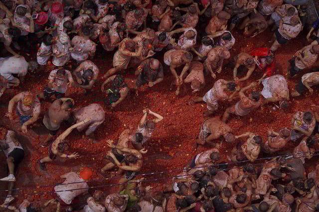 Revelers throw tomatoes at each other during the annual "Tomatina" tomato fight fiesta, in the village of Bunol near Valencia, Spain, Wednesday, Aug. 27, 2025. (AP Photo/Alberto Saiz)