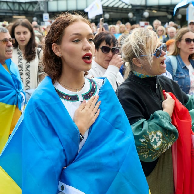 Teilnehmer einer Demonstration am Unabhängigkeitstag der Ukraine singen am Hamburger Hauptbahnhof.