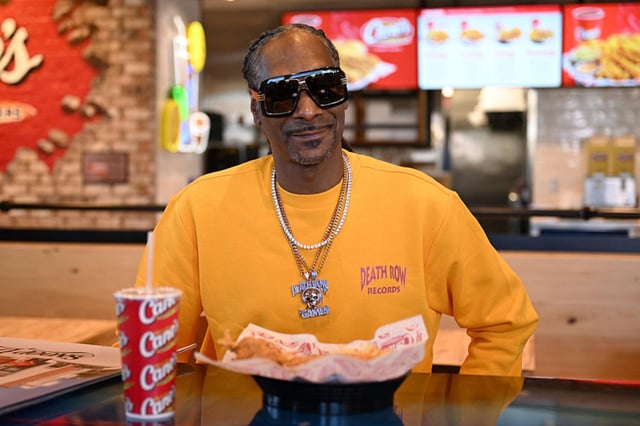 LAS VEGAS, NEVADA - JULY 23: Snoop Dogg works a surprise "shift" at Raising Cane's in Vegas ahead of National Chicken Finger Day on July 27 at Raising Cane's on July 23, 2025 in Las Vegas, Nevada.