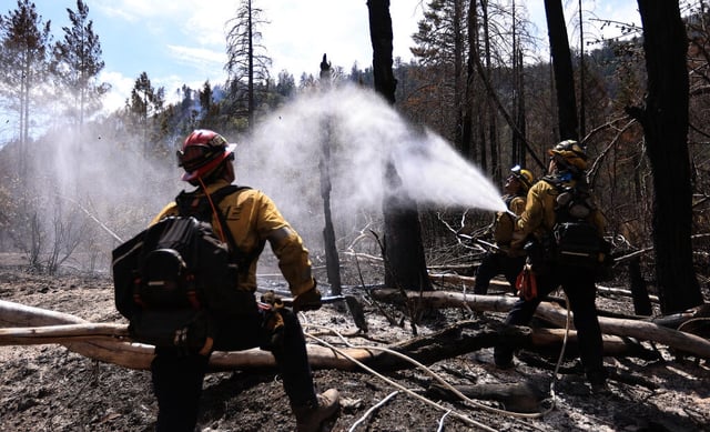Cal Fire’s Fresno Kings Unit firefighters Louis Zervoudakis, Brandon Weiler and Joseph Valencia mop of their section of the Pickett Fire above Aetna Springs, Tuesday, August 26, 2025. Because of predicted outflow winds from thunderstorms, crews are putting out smokes 300 feet from containment lines. (Kent Porter / The Press Democrat)