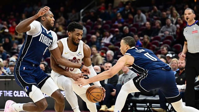 Feb 2, 2025; Cleveland, Ohio, USA; Cleveland Cavaliers guard Donovan Mitchell (45) drives to the basket between Dallas Mavericks forward Olivier-Maxence Prosper (8) and guard Dante Exum (0) during the second half at Rocket Mortgage FieldHouse. Mandatory Credit: Ken Blaze-Imagn Images