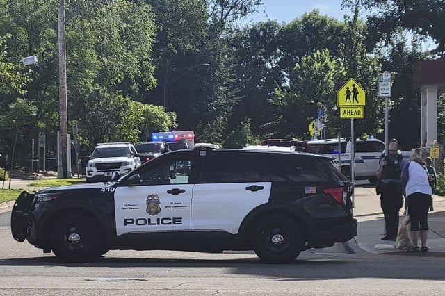 Agentes del orden público se reúnen frente a la escuela de la Iglesia de la Anunciación en respuesta a un tiroteo masivo reportado, el miércoles 27 de agosto de 2025, en Minneapolis