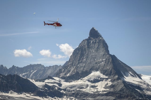 An Air Zermatt helicopter flying near the Matterhorn mountain