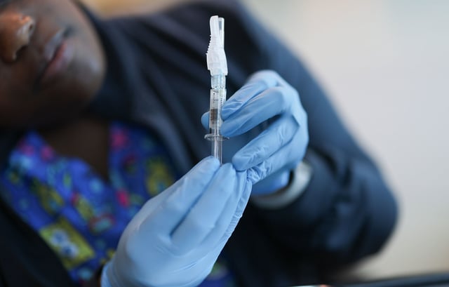 MIAMI, FLORIDA - MAY 29: In this photo illustration, Ruth Jones, Immunization Nurse, holds a Pfizer-BioNTech COVID-19 vaccine (brand name: Comirnaty) at Borinquen Health Care Center on May 29, 2025 in Miami, Florida. Health Secretary Robert F. Kennedy Jr. announced that he will no longer recommend that healthy children and pregnant people get COVID-19 shots. (Photo illustration by Joe Raedle/Getty Images)