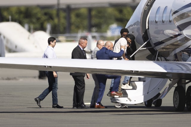 Harjinder Singh is escorted onto an airplane by Florida Lt. Gov. Jay Collins and law enforcement on Thursday, Aug. 21, 2025, in Stockton, Calif. (AP Photo/Benjamin Fanjoy)