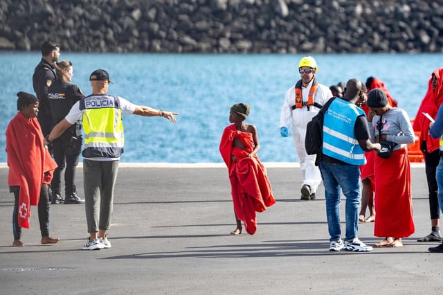 Archivo - Agentes de los equipos de emergencia atienden a los migrantes menores en el muelle de Arrecife.