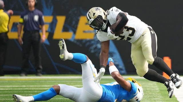 Aug 10, 2025; Inglewood, California, USA; New Orleans Saints running back Clyde Edwards-Helaire (23) carries the ball against Los Angeles Chargers cornerback Jordan Oladokun (37) in the second half at SoFi Stadium. Mandatory Credit: Kirby Lee-Imagn Images