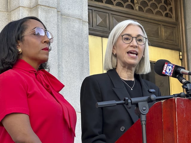 Fulton County Commissioner Dana Barrett (right) speaks outside the Fulton County courthouse in Atlanta on Wednesday, Aug. 27, 2025, while her colleague, Commissioner Mo Ivory, looks on. (AP Photo/Kate Brumback)