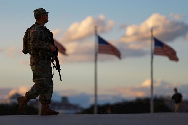 A member of the National Guard carries a firearm while patrolling the National Mall in Washington, DC on Tuesday.