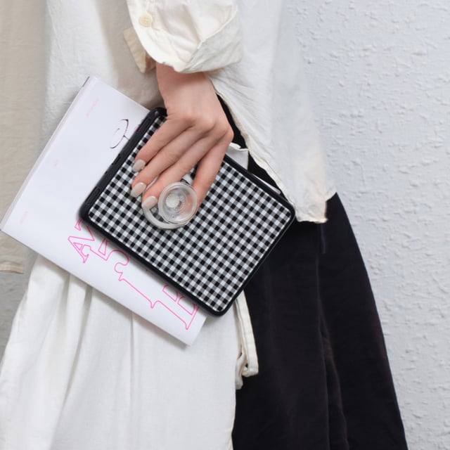 A person holding a Kindle with a PopSockets case and grip on it.
