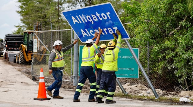 Workers install a permanent Alligator Alcatraz sign, in Collier County, Florida, on July 3, 2025. (Al Diaz/Miami Herald/TNS)
