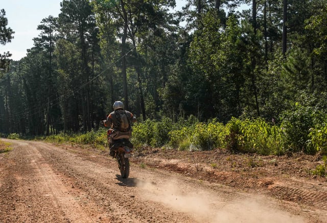 Sam Houston Trails Coalition volunteer Billy Clicks, 76, rides his dirt bike through the Sam Houston National Forest on Wednesday, Aug. 21, 2024 in New Waverly. 