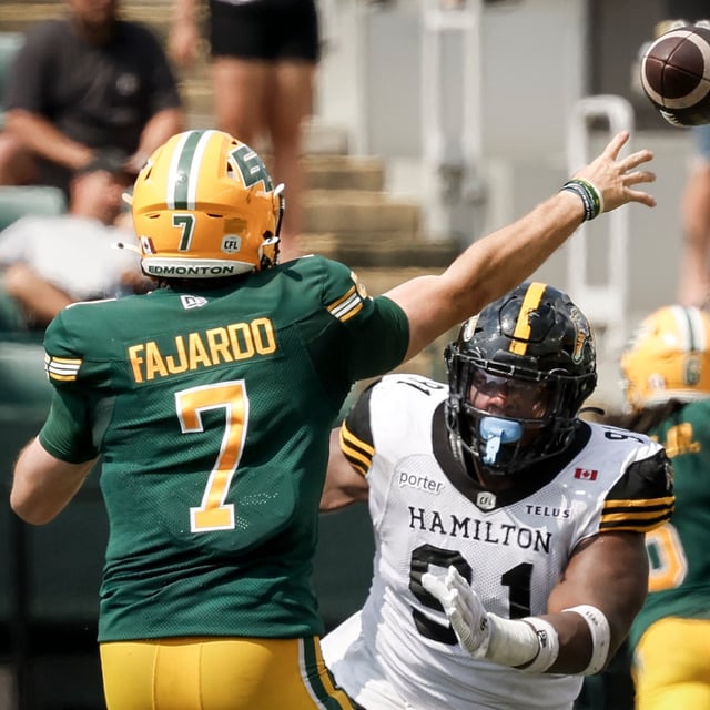 Hamilton Tiger-Cats' Miles Fox, right, rushes Edmonton Elks quarterback Cody Fajardo during second half CFL football action in Edmonton, Saturday, Aug. 2, 2025. THE CANADIAN PRESS/Jeff McIntosh