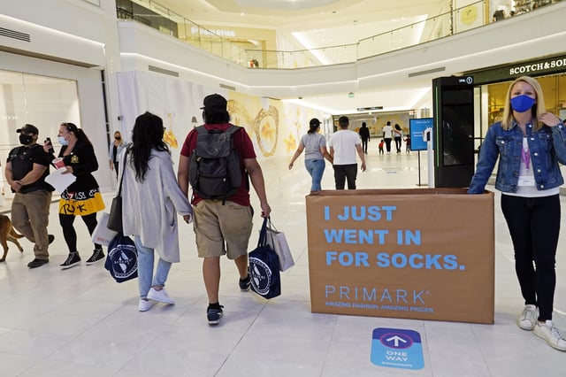 FILE - In this Thursday, Oct. 1, 2020, file photo, shoppers and pedestrians walk through a concourse at the American Dream Mall in East Rutherford, N.J. (AP Photo/Kathy Willens, File)